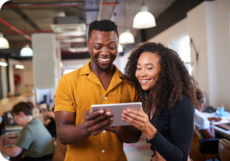 A man and woman looking at a tablet together